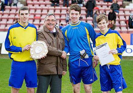 Declan Boyle, goalkeeper Nathan Harkin and and Declan Wilson receiving the trophy from Interim Chairman Bob Garmory